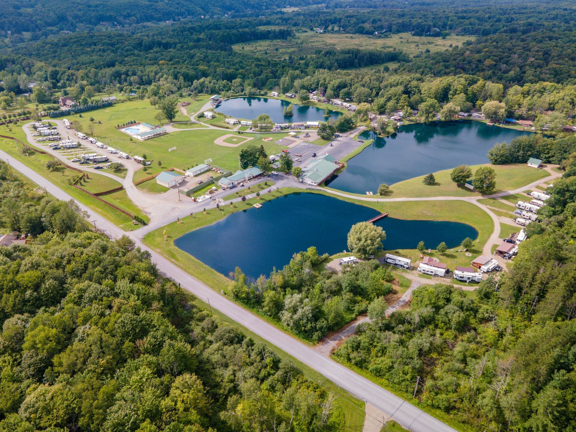 an aerial view of a lake surrounded by trees and rv spaces.