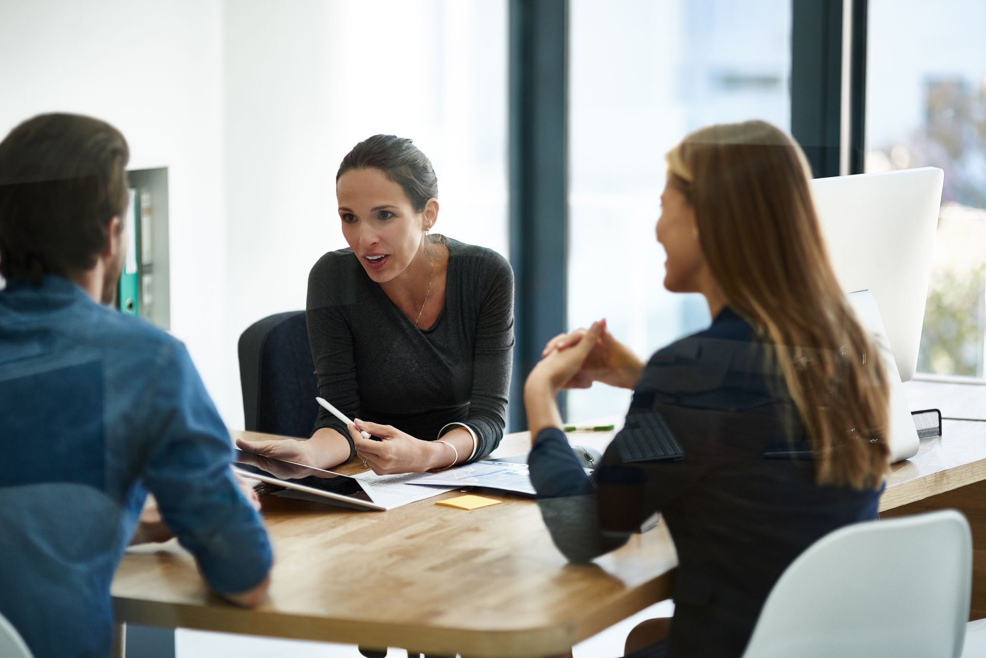 Two women and one man sitting at desk