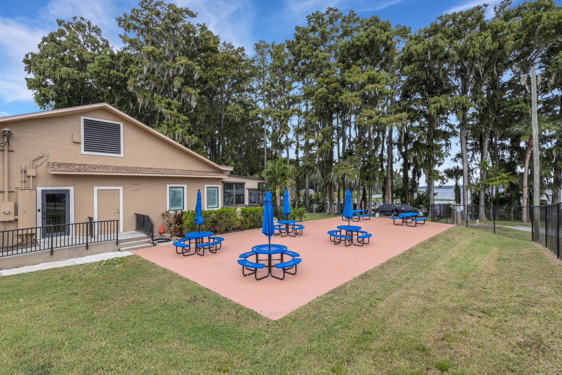 Row of modern townhouses with colorful exteriors, green lawns, and blue sky.