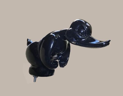 Black, glossy Daffy Duck hood ornament, positioned at an angle, on a neutral background.