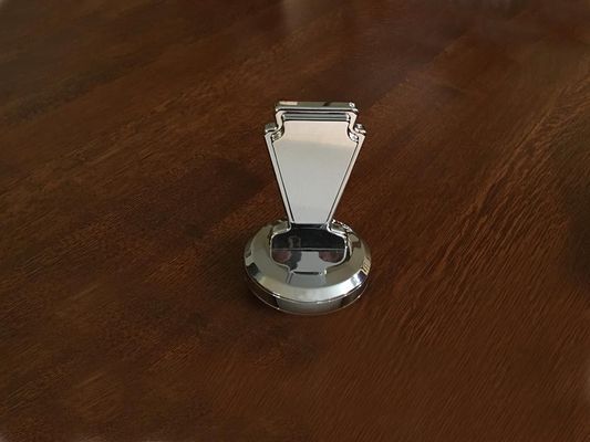 Silver ashtray on a brown wooden surface.