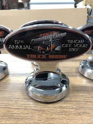 Shiny truck show trophy. Oval black and orange design, chrome base.