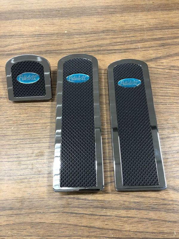 Three black and silver vehicle floor mats with blue logo details.