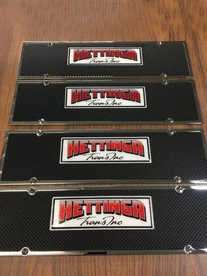 Four black and silver license plate frames with the logo