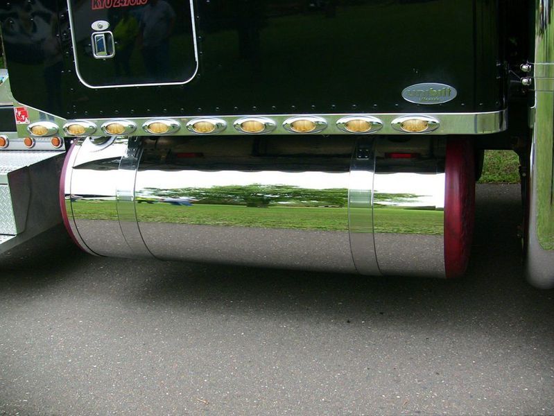 Chrome fuel tank on a black semi-truck, red ends, lights above.