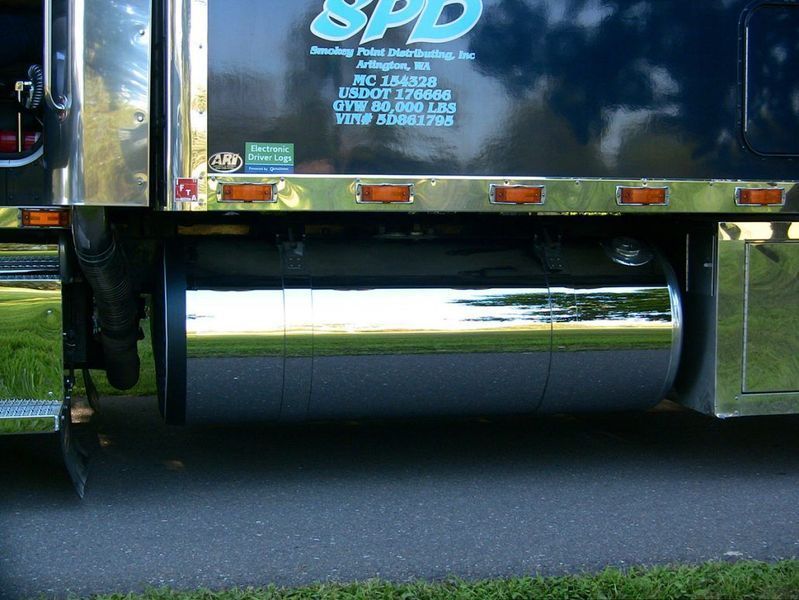 Shiny chrome fuel tank on a black semi-truck.