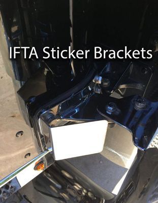 Close-up of a truck's front with a white sticker bracket. 