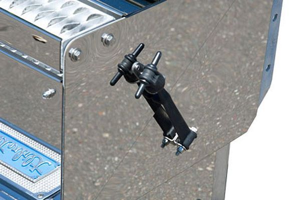 Black adjustable latch on a shiny, silver metal surface, likely part of a vehicle.