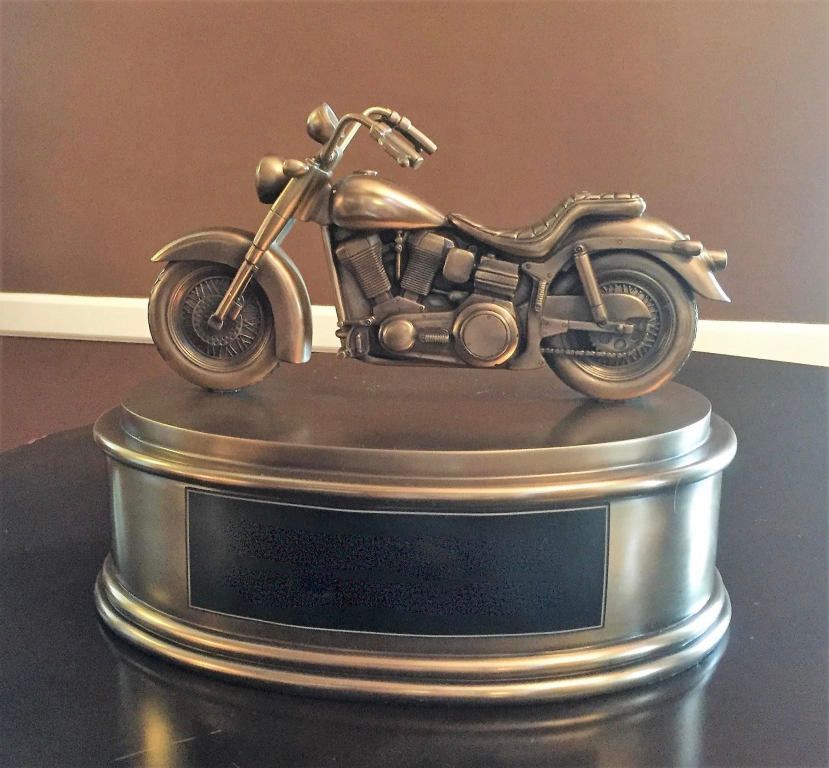 A bronze statue of a motorcycle on a pedestal