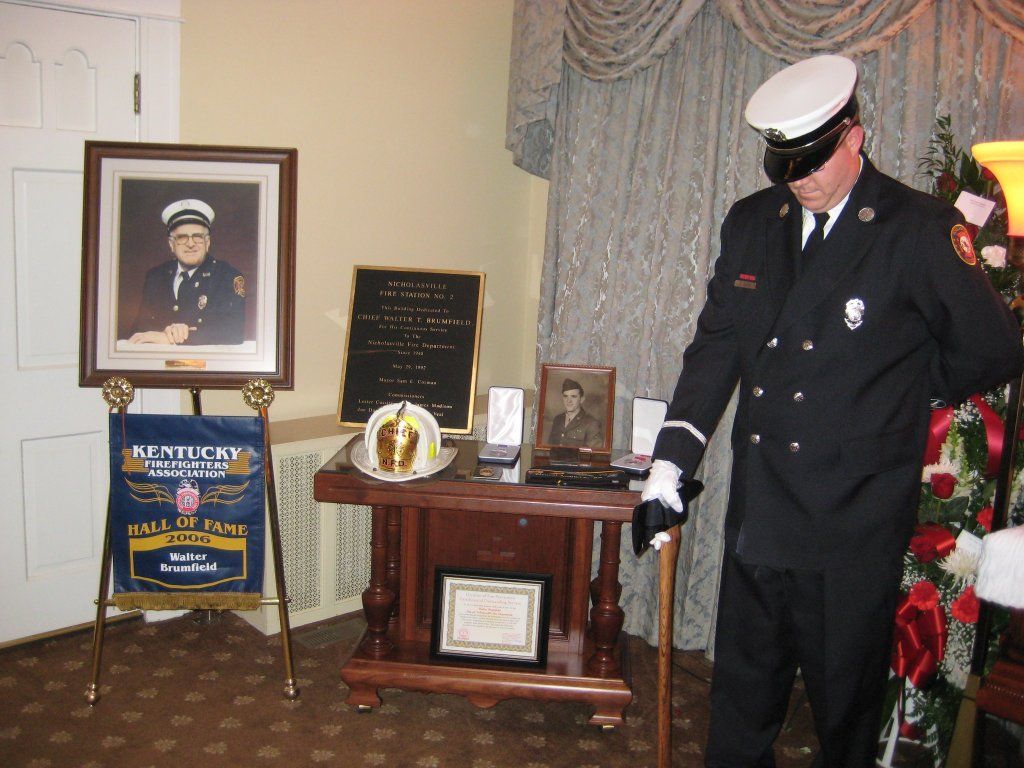A man in a firefighter uniform is standing in front of a table