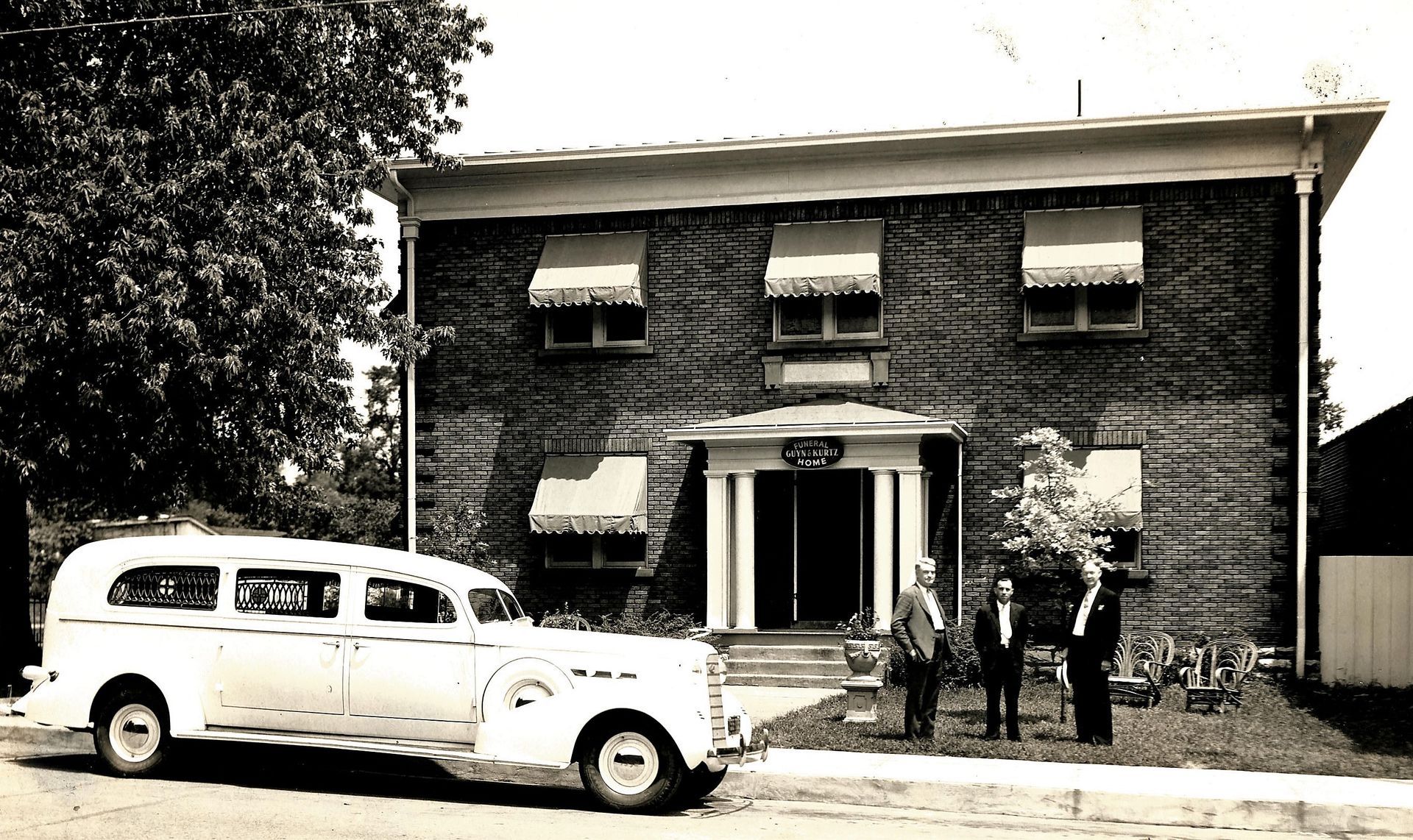 A white ambulance is parked in front of a large brick building
