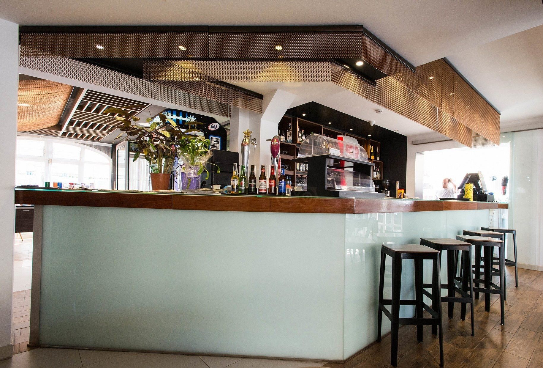 A bar with stools and bottles on it
