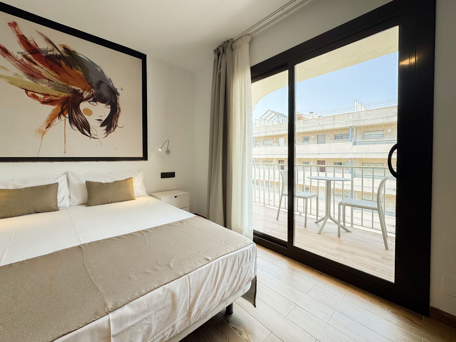 Una habitación de hotel con una cama king size y un balcón.