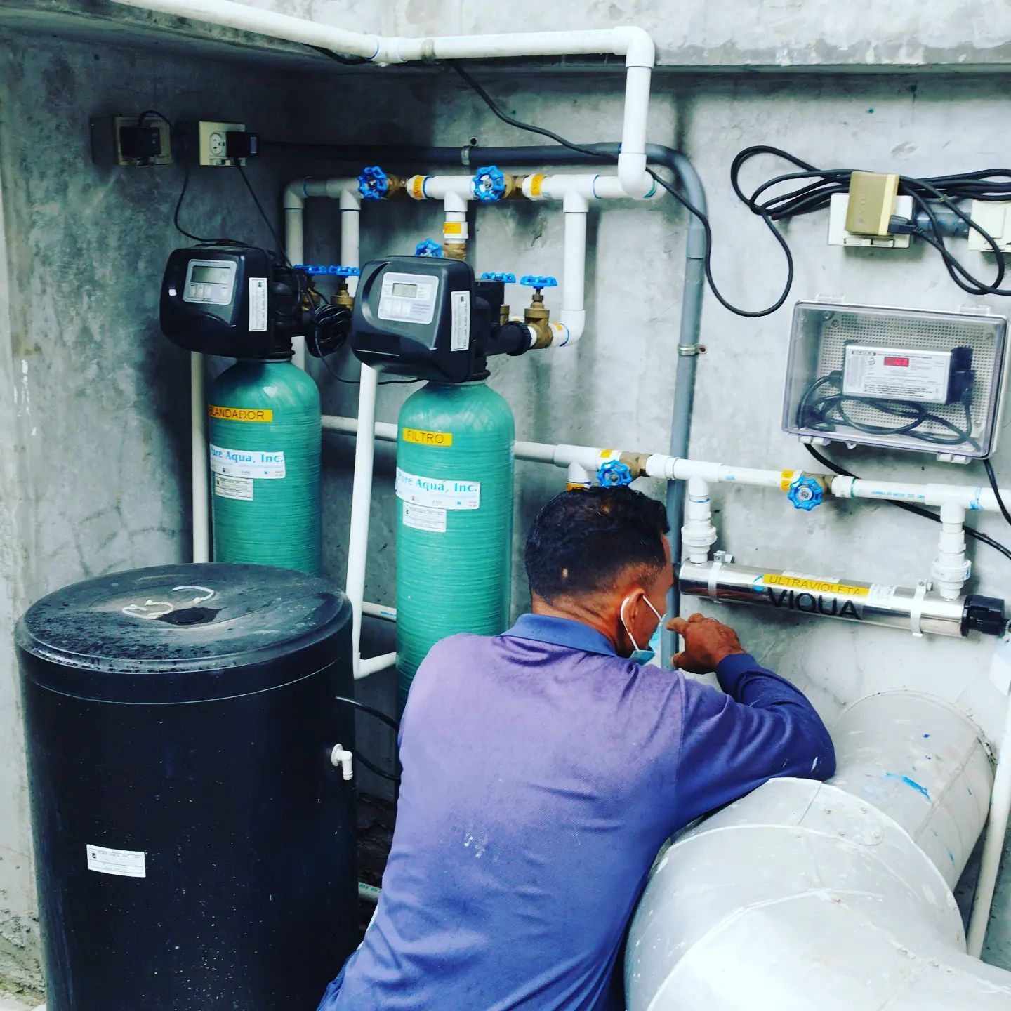 Un hombre con una máscara está trabajando en un sistema de agua.