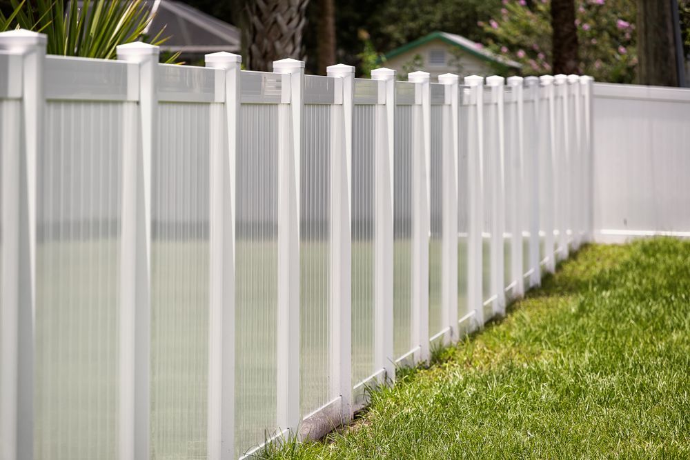 A White Vinyl Fence in Front of Green Grass — Smiddy's Services In The Entrance, NSW