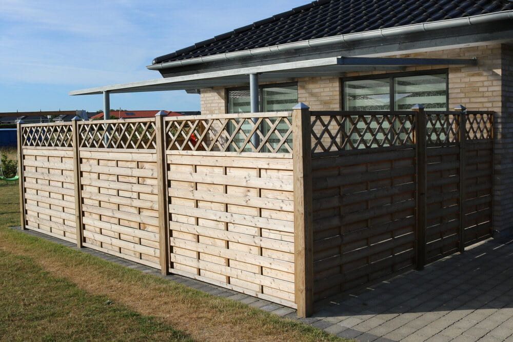 A Brick House With A Wooden Fence In Front Of It — Smiddy's Services In Gosford, NSW