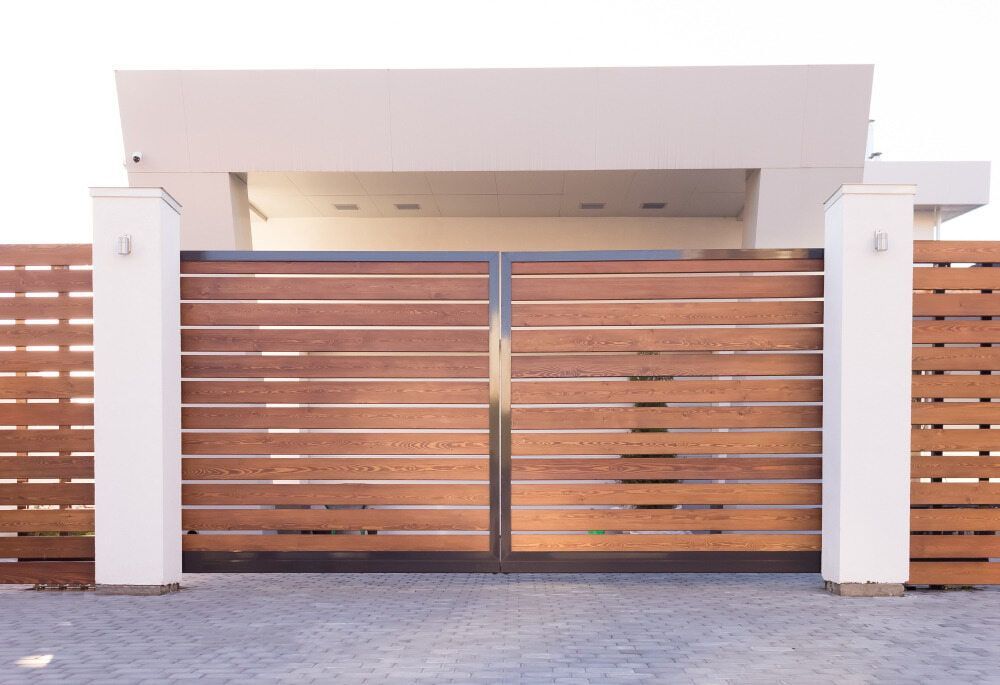 A White Building With A Wooden Gate In Front Of It — Smiddy's Services In Wyong, NSW