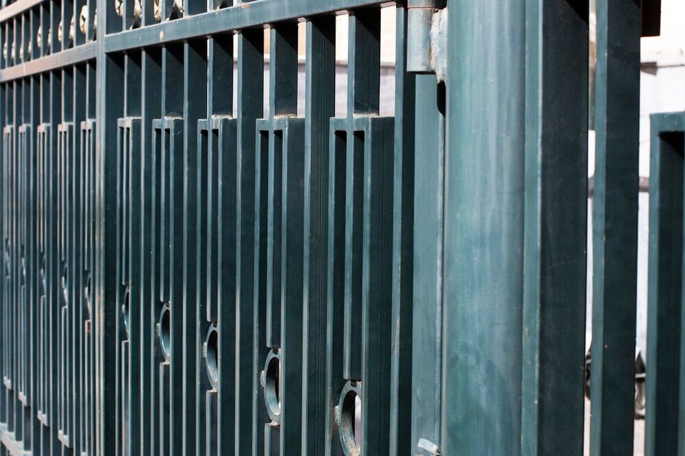 A Close Up Of A Metal Fence With Holes In It — Smiddy's Services In Lake Macquarie, NSW