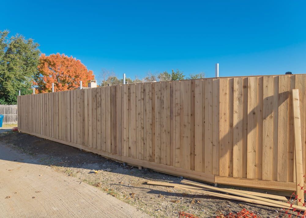 A Wooden Fence Is Being Built On A Dirt Road — Smiddy's Services In Tacoma, NSW
