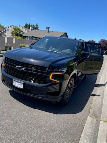 A black chevrolet suv is parked on the side of the road.