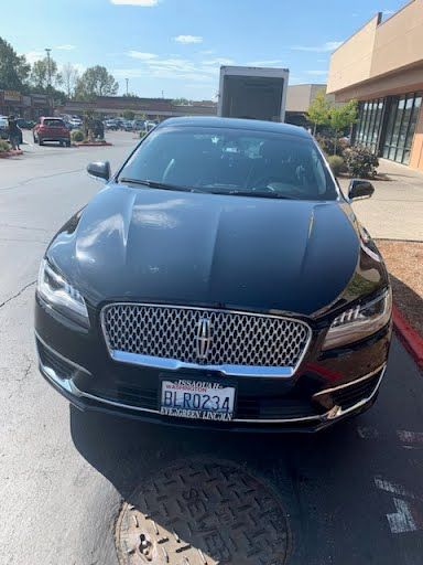 A black lincoln continental is parked in a parking lot.