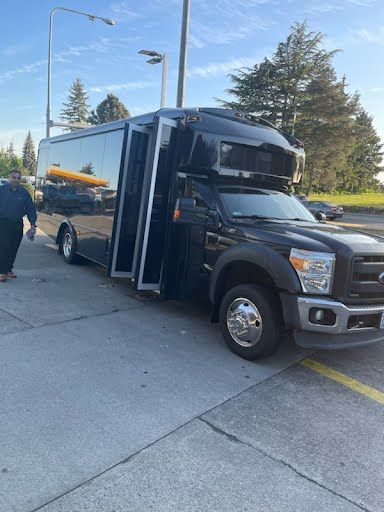 A black shuttle bus is parked on the side of the road.