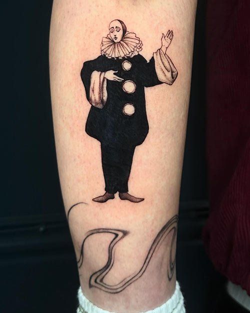 A person has a tattoo of a clown on their leg