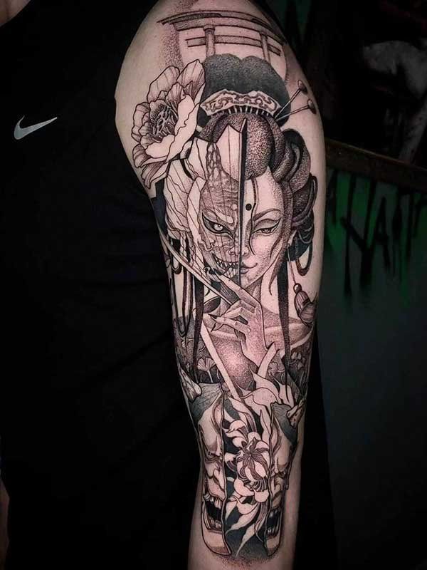 A black and white tattoo of a geisha with a mask on her face on a man 's arm.