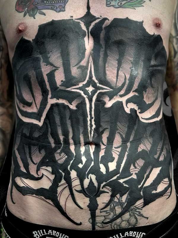 A man has a tattoo on his stomach that says billabong