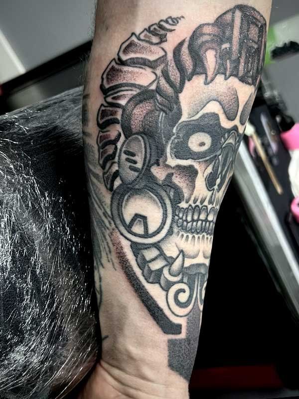 A person has a tattoo of a skull on their forearm.