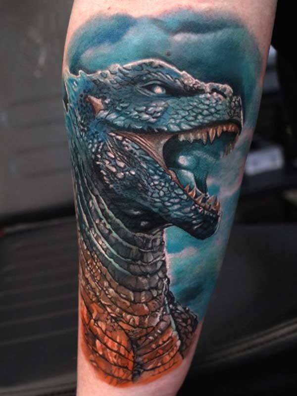 A person has a tattoo of a dragon on their leg.