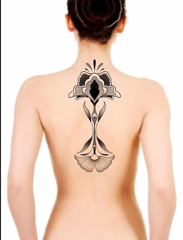 A woman has a tattoo of a flower on her back