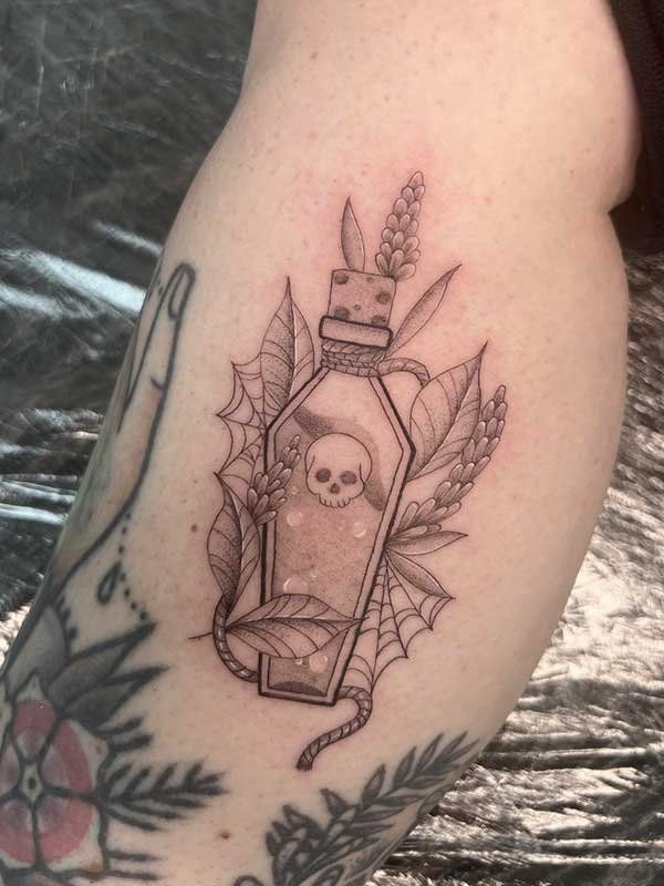 A tattoo of a coffin with a skull in it