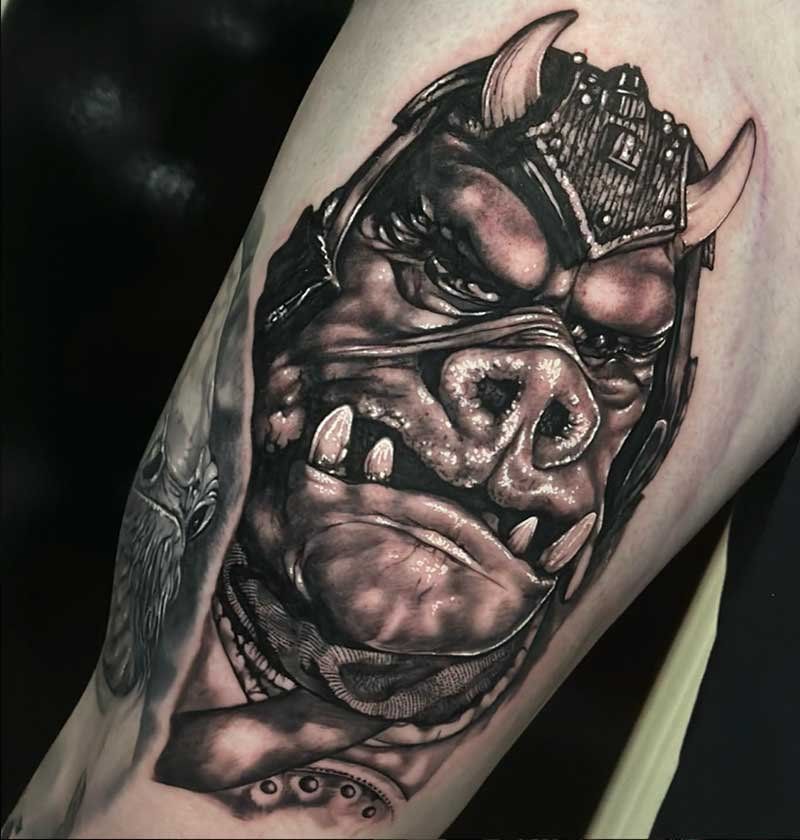 A black and white tattoo of a monster with horns