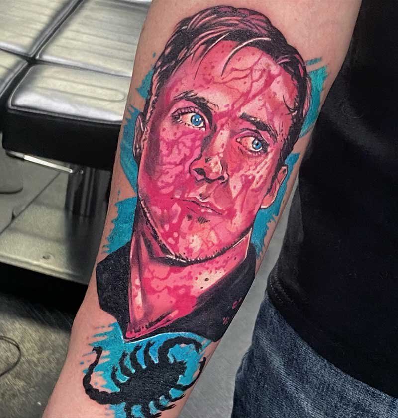 A person has a tattoo of a man 's face and a scorpion on their arm.
