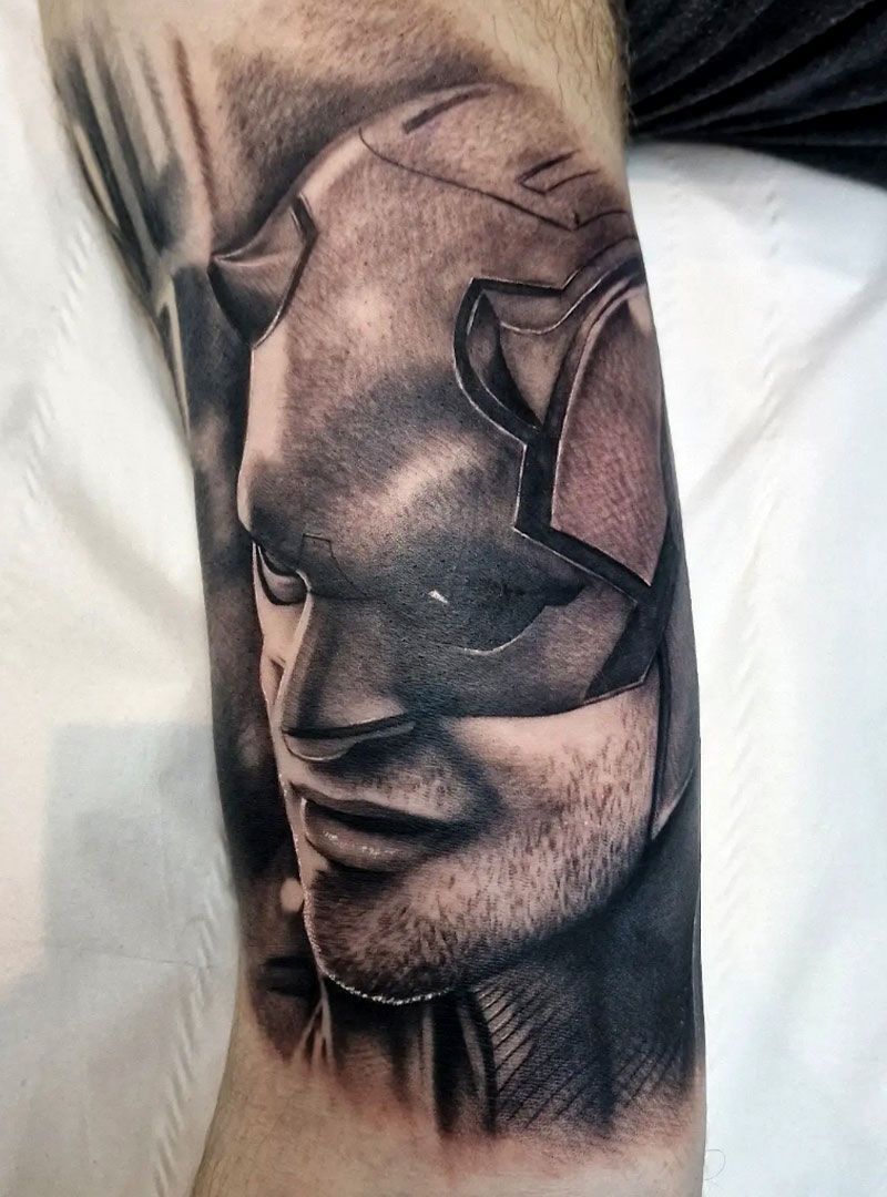 Abstract black-and-gray face tattoo on skin, with angular geometric shapes and shaded features