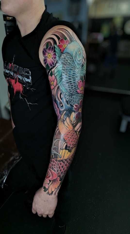A man with a colorful tattoo on his arm and shoulder.