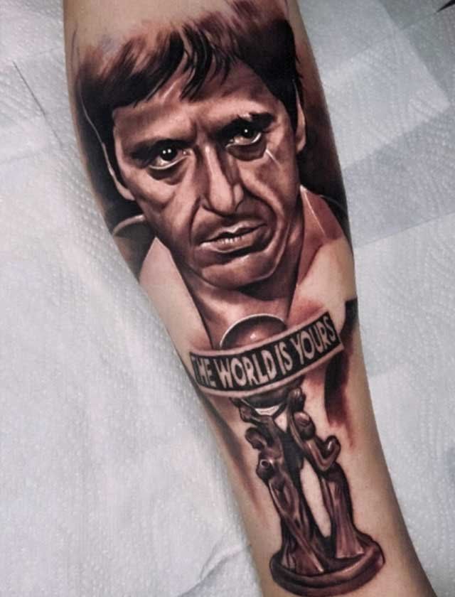 A tattoo of a man with the words the world is yours on his arm
