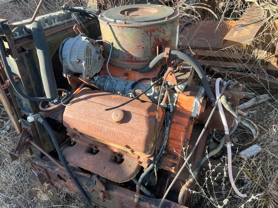 An old rusty engine is sitting in the dirt.