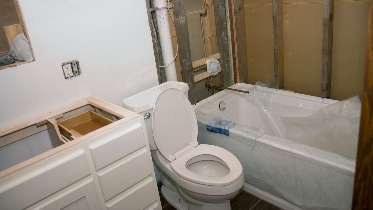 Bathroom installation in process with toilet, bath, and sink unit.