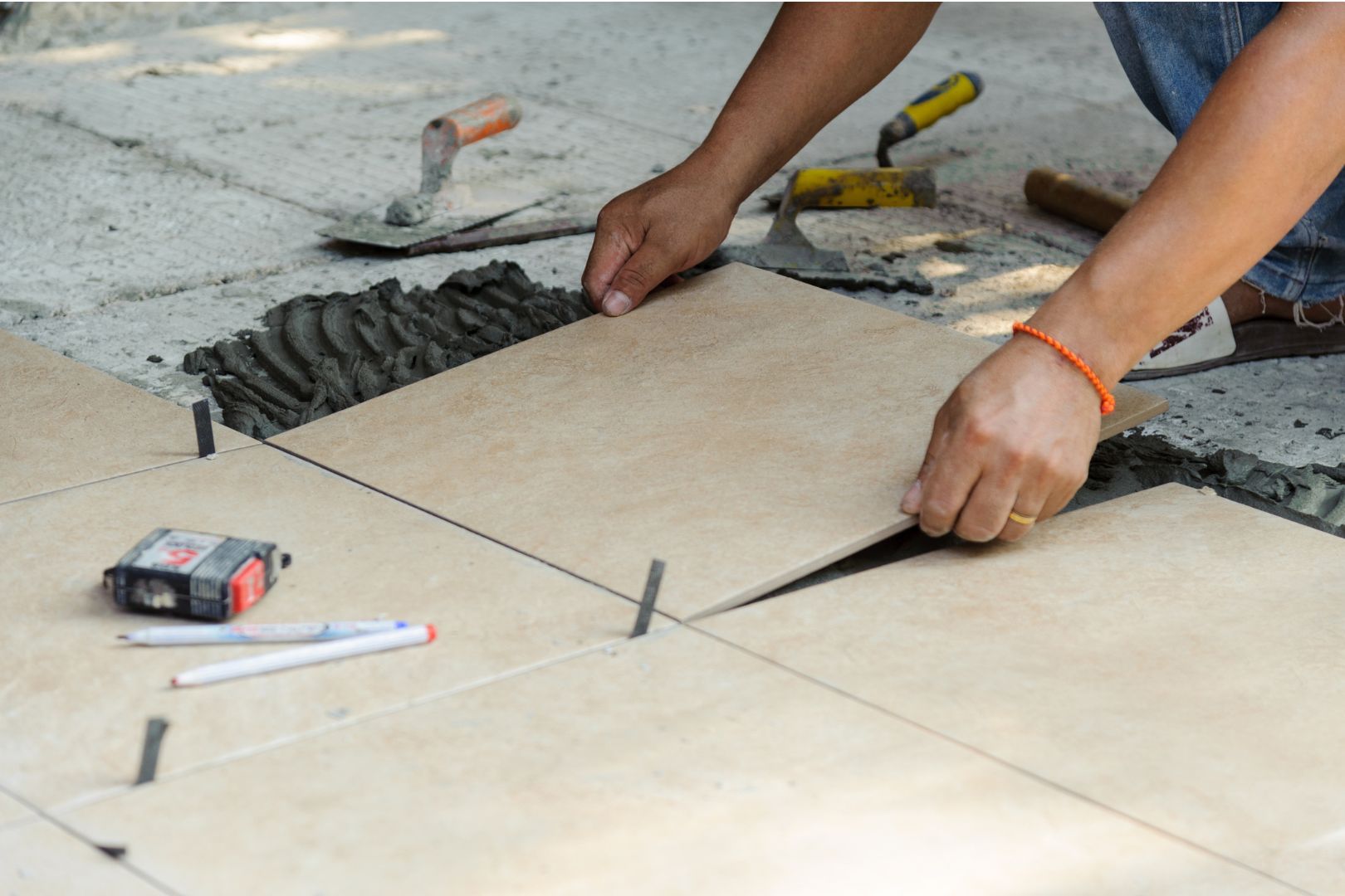 Bathroom tiles installation process with grout and porcelain tiles.