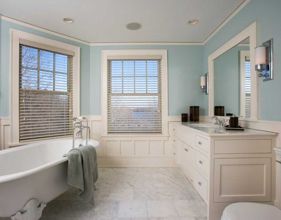 Traditional bathroom with a big free-standing bath and two sinks. The room has a white theme.