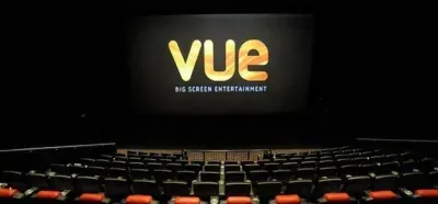 Black cinema screen and red seats in front of it.