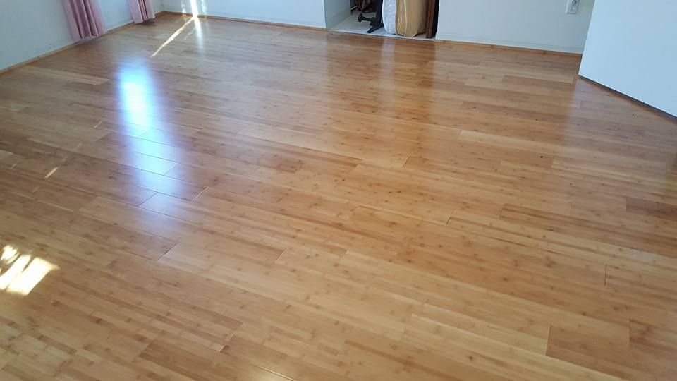 Shiny, light-brown hardwood flooring.  Sunlight reflects off the polished surface.