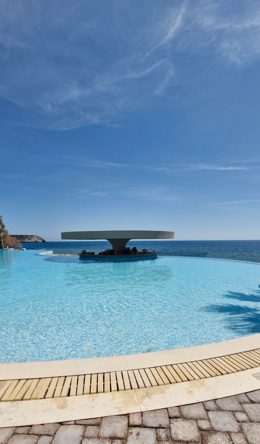 There is a diving board in the middle of the pool.