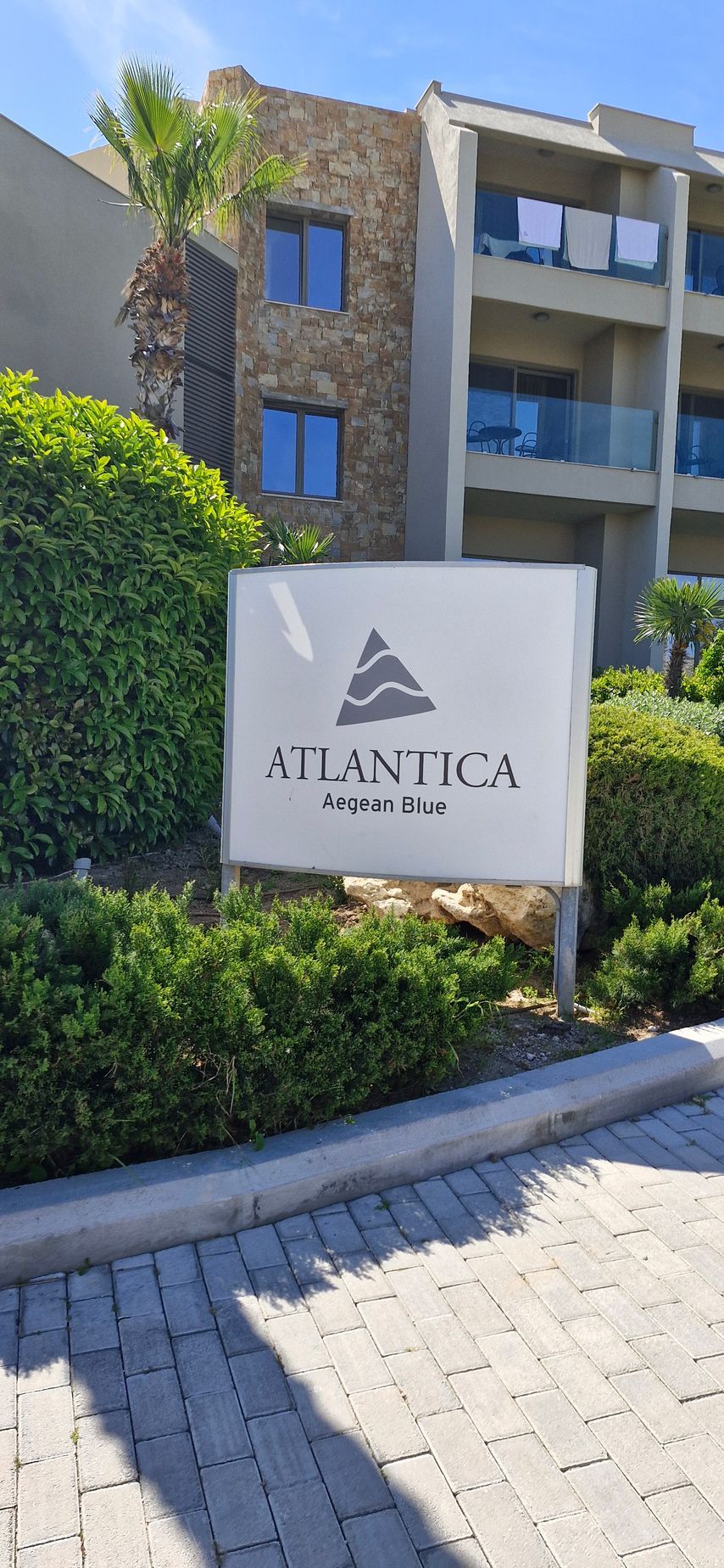 A sign for atlantica hotel is in front of a building.