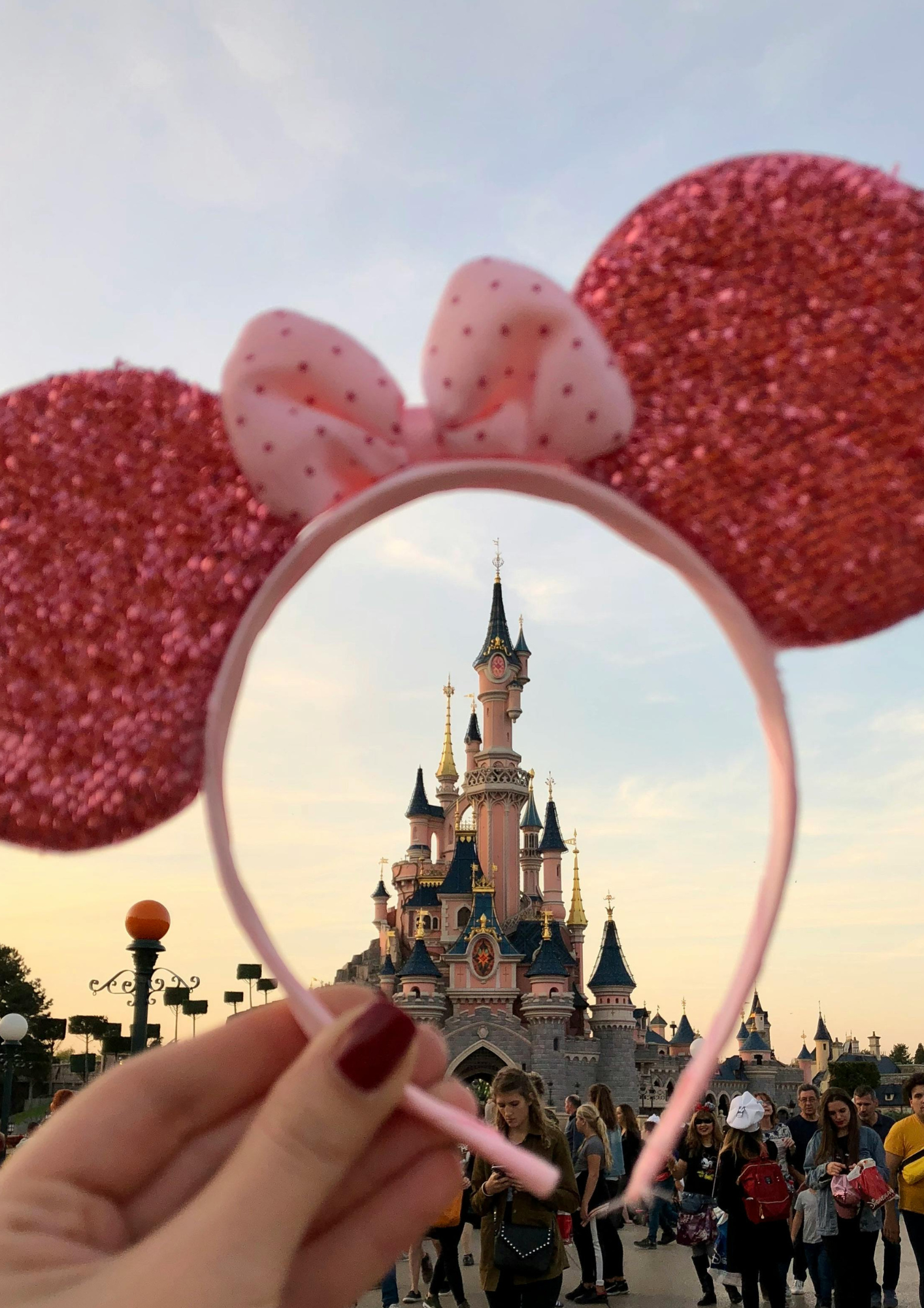 A person is holding a headband with minnie mouse ears on it
