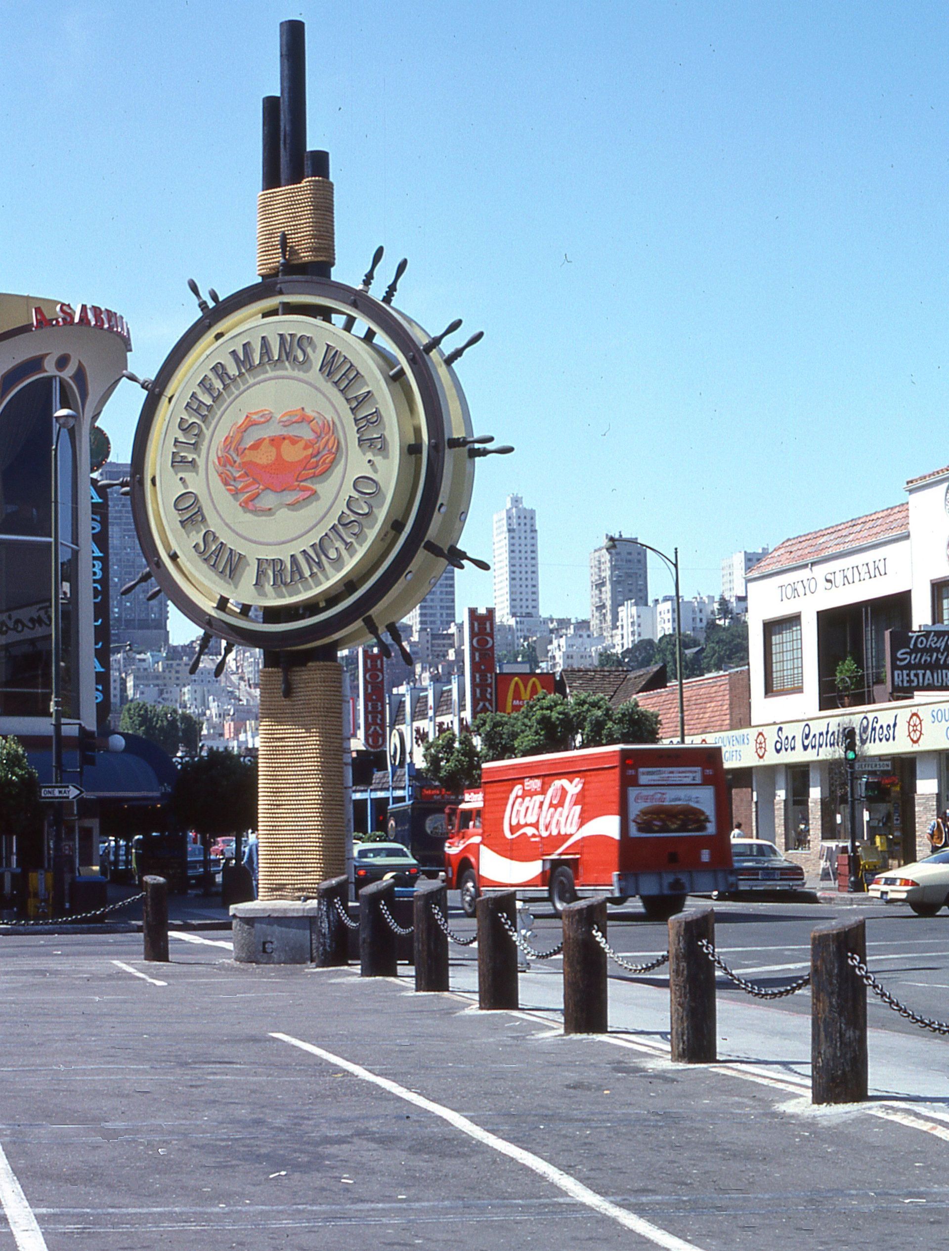 Moulin Rouge sign in a city street with a Coca-Cola truck and tall buildings in the background