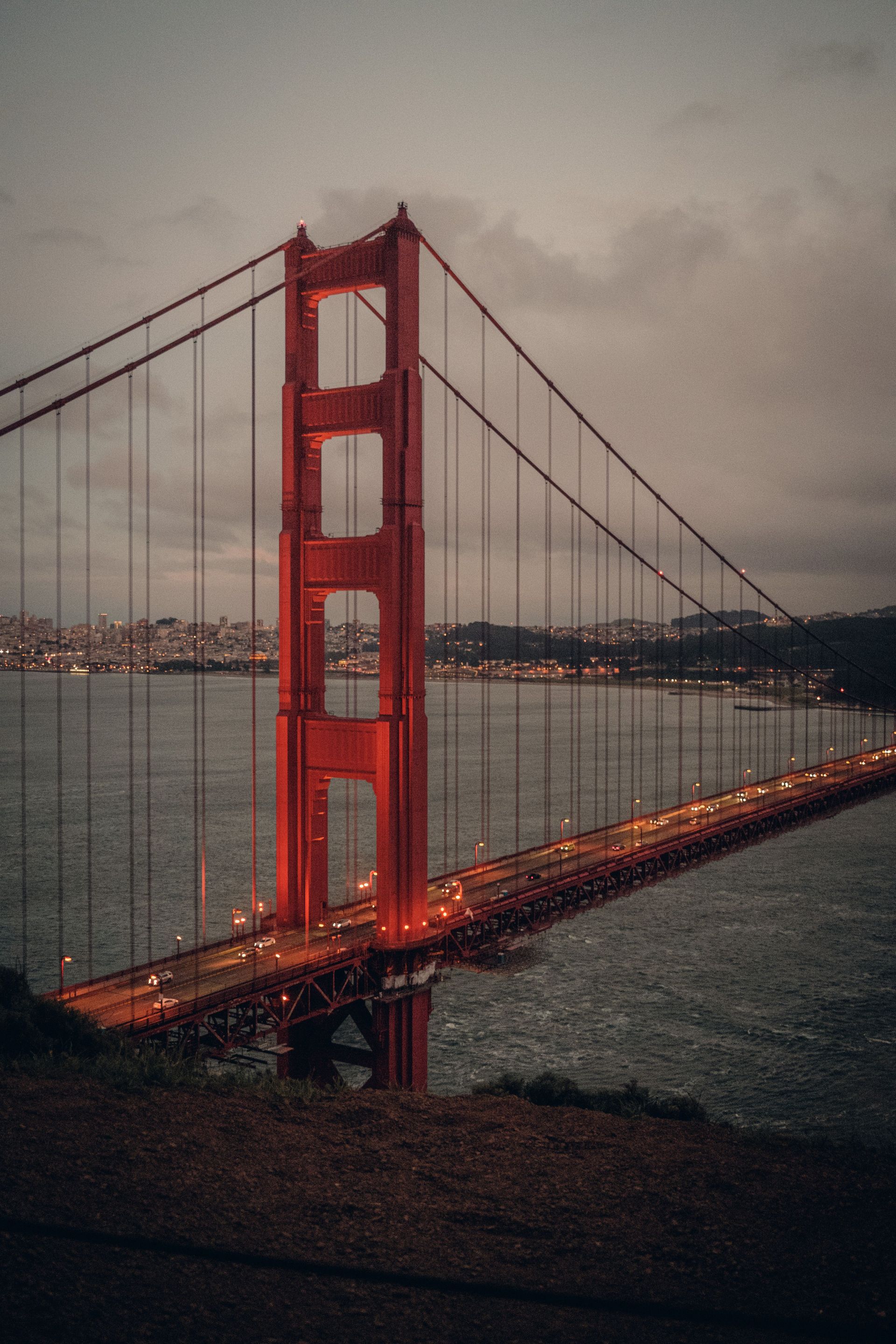Golden Gate Bridge with red towers spanning a foggy bay under overcast skies