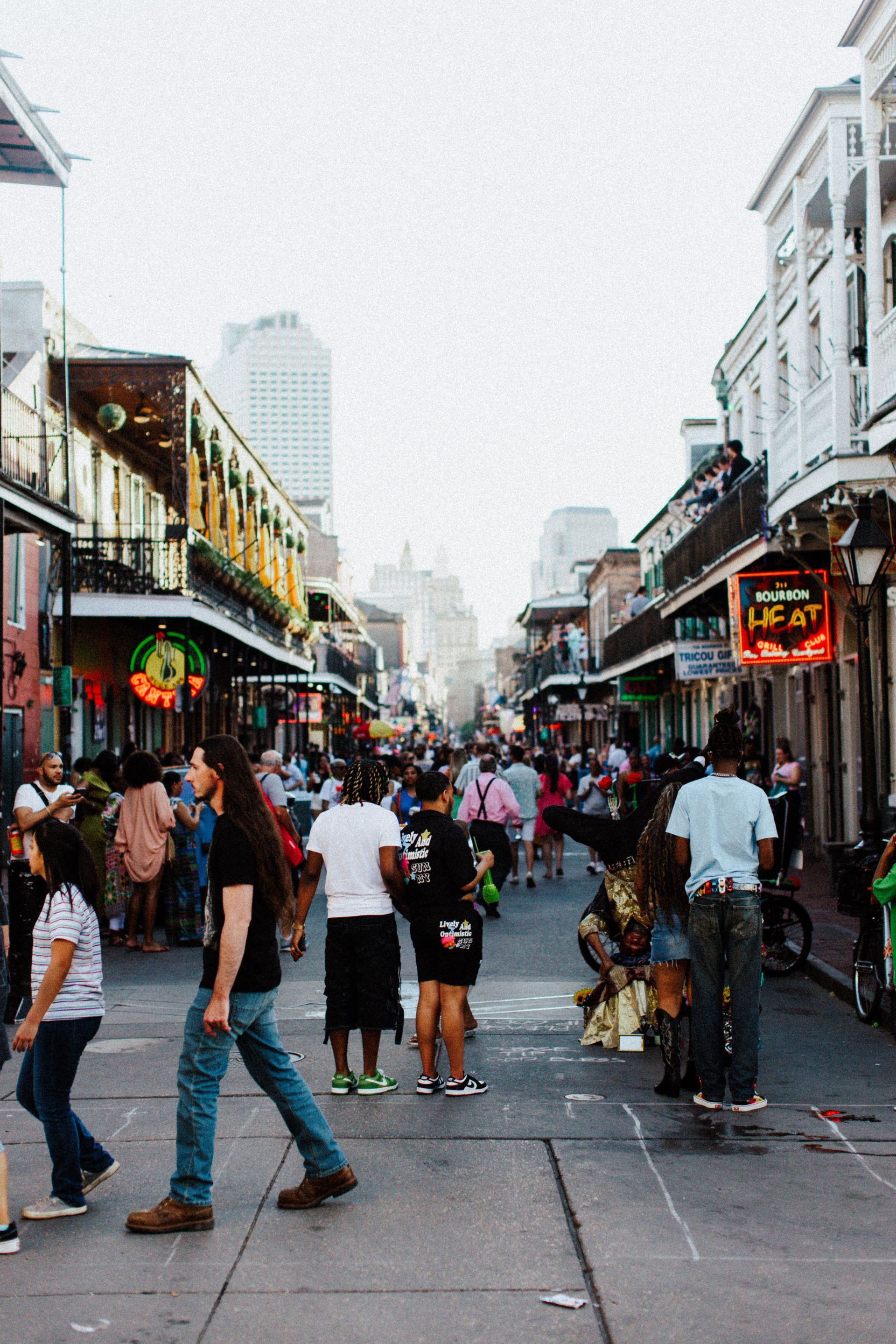 Crowded pedestrian street lined with shops and neon signs on a foggy day
